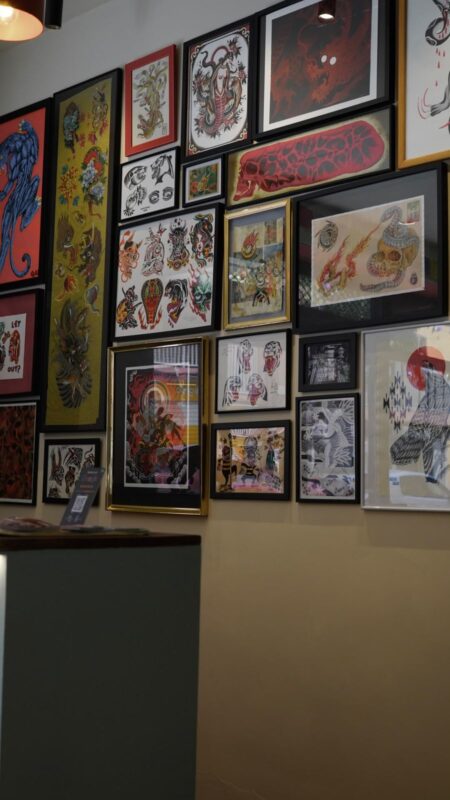 Pared del estudio cubierta de láminas de flash enmarcadas, unas sobre otras, de suelo a techo.